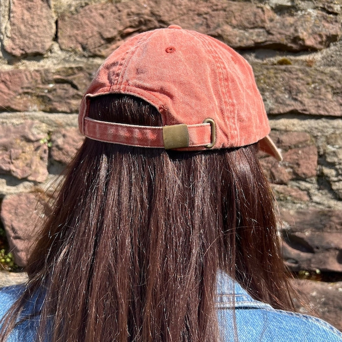 Model trägt Vintage Cap in der Farbe peach mit Metallverschluss von hinten