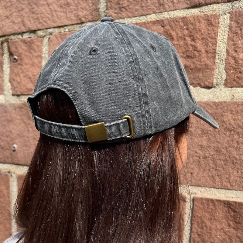 Model trägt Vintage Cap in schwarz mit Metallverschluss von hinten