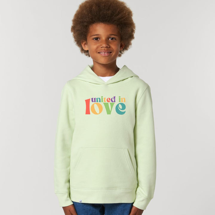Kind lächelt und trägt Hoodie in der Farbe Lime mit dem Aufdruck united in love