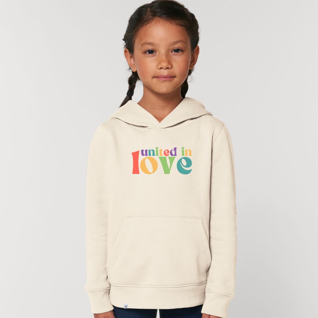 Kind lächelt und trägt Hoodie in der Farbe Natur mit dem Aufdruck united in love