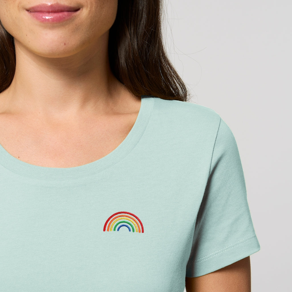 Nahaufnahme eines karibikblauen Shirts mit einem gestickten Regenbogen