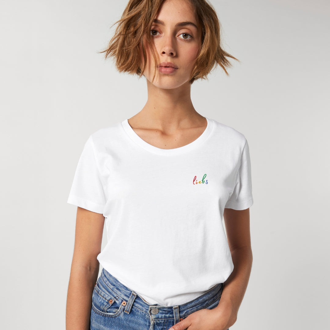 Person trägt ein weißes Shirt mit dem Stickdesign liebs in Regenbogenfarben
