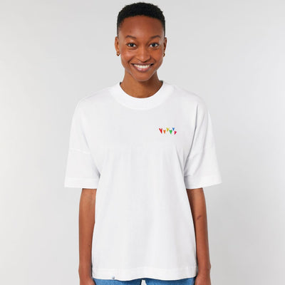 Model trägt oversized Shirt Regenbogenherzen Stick in der Farbe  Weiß.