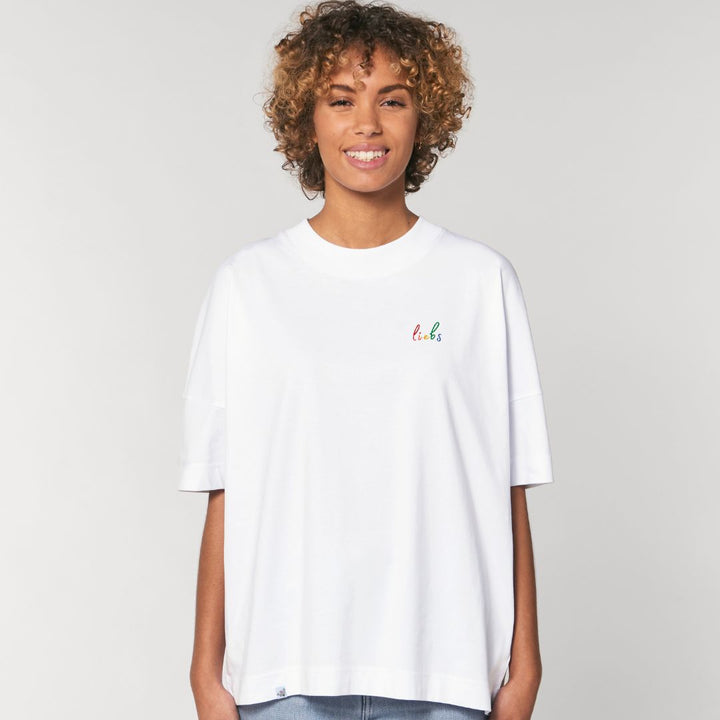 Model trägt oversized Shirt mit dem Stickdesign liebs auf der Brust in der Farbe Weiß.