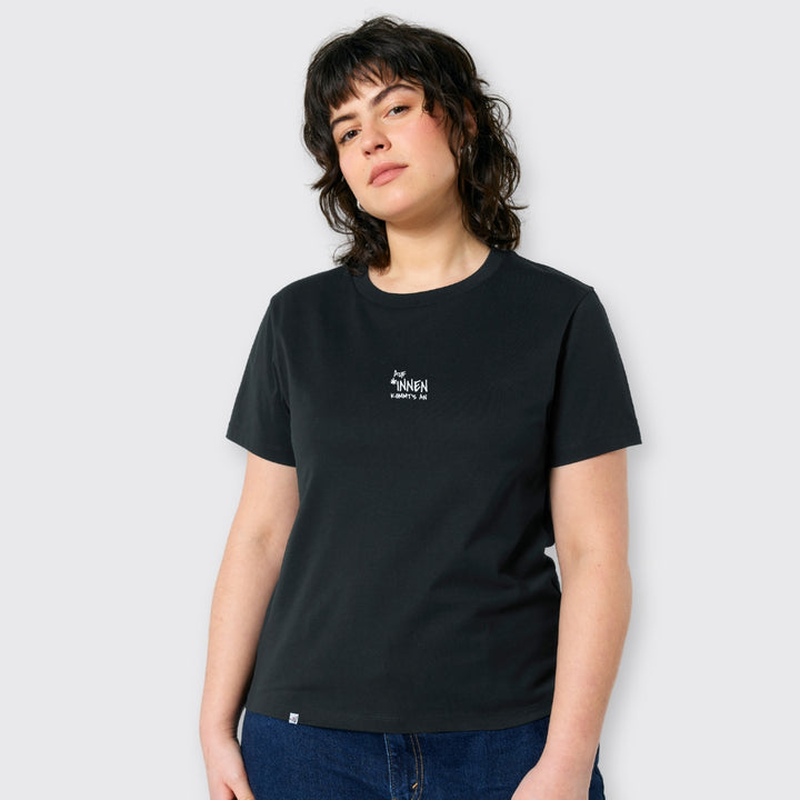 Model schaut in die Kamera und trägt schwarzes Shirt mit dem Stick Auf *innen kommt's an