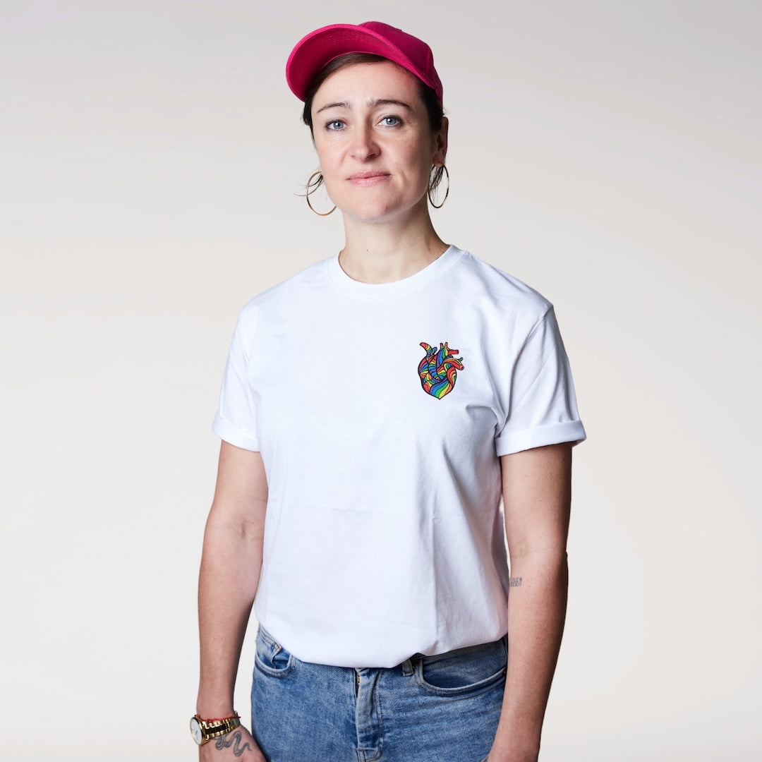 Model trägt weißes Shirt mit anatomischen Herz in Regenbogenfarben