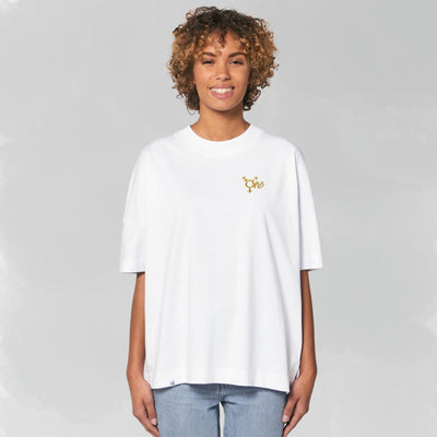 Model trägt weißes oversized Shirt mit dem All Gender Symbol ONE in goldenem Stick
